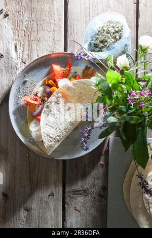 Tortilla-Wraps gefüllt mit Ziegenkäse und Antipasti-Gemüse Stockfoto