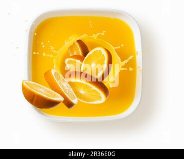 Orangen mit einem Spritzer Saft Stockfoto