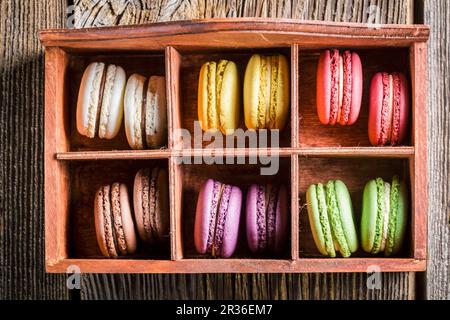 Bunte makronen in einer alten Holzkiste Stockfoto