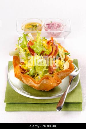 Frisee-Salat mit Speck, Ei und zwei Salatdressings Stockfoto