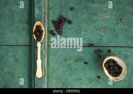 Getrocknete Preiselbeeren auf einem Löffel und in einer Schüssel auf rustikaler Oberfläche Stockfoto