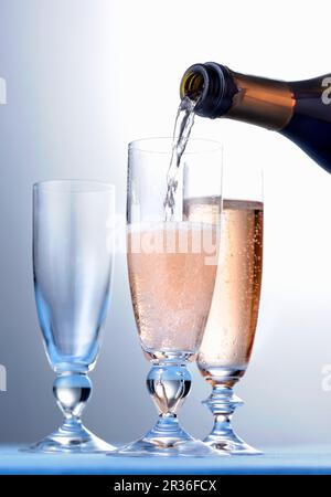 Rosé-Champagner wird eingegossen Stockfoto