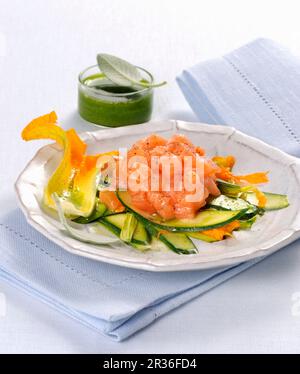Lachs-Tartare auf einem Courgette-Medley mit Kräutersauce Stockfoto