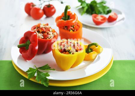 Rot, Gelb und Orange Paprika mit Reis, Pfeffer und Tomaten Salat gefüllt Stockfoto