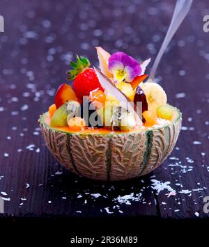 Obstsalat in einer Melonenhälfte serviert Stockfoto