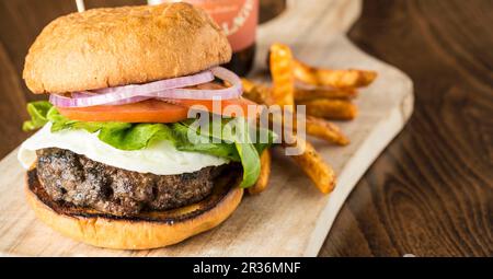 Ein Burger mit Spiegelei und Pommes Stockfoto