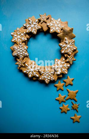 Ein Kranz aus gefrorenen Lebkuchen-Sternen auf blauem Hintergrund Stockfoto