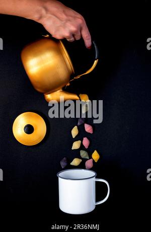 Shell Pasta aus einer Teekanne in ein Emaille Tasse gegossen Stockfoto