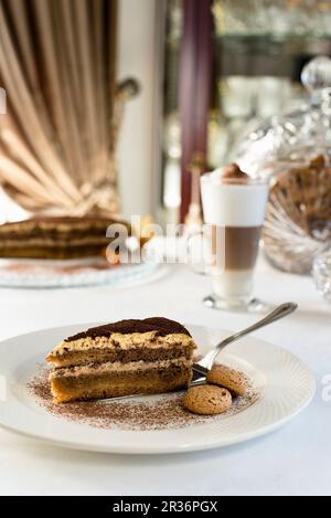 Tiramisu-Kuchen mit Mascarpone-Mousse, garniert mit Kaffee und Kakaopulver und serviert mit Mandelbiscotti Stockfoto