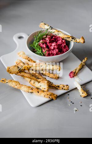 Rote Beete & Feta-Käse-Dip mit herzhaften Blätterteig-Trinkhalmen, garniert mit Dill Stockfoto