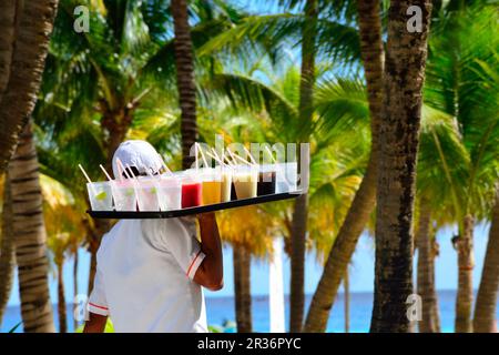 Im karibischen Ferienresort wird ein großes Tablett mit Getränken geliefert Stockfoto