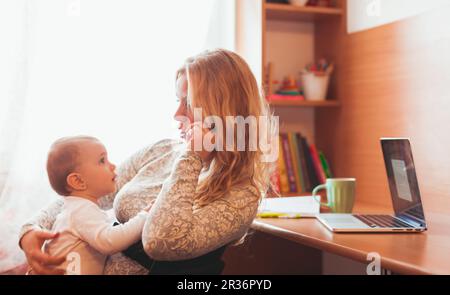 Freiberuflich arbeitete Mama mit baby Stockfoto