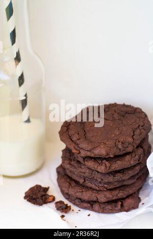 Schokoladenkekse aus Bohnen neben einer Flasche Milch Stockfoto