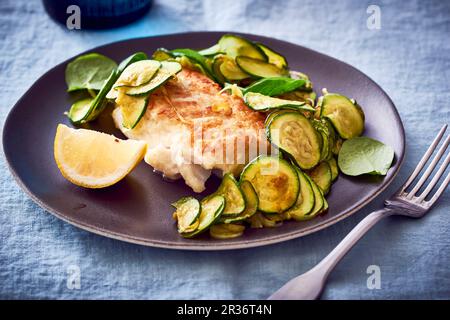 In der Pfanne gebratener Kabeljau mit Zucchini Stockfoto