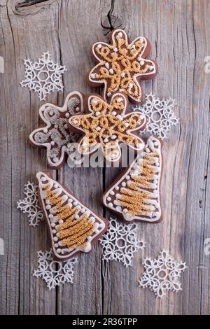 Weihnachts-Lebkuchen (in Form von Sternen und Glocken) auf einer Holzfläche Stockfoto