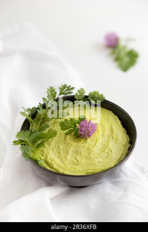 Avocado dip in eine Schüssel geben. Stockfoto