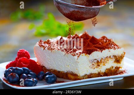 Tiramisu wird mit Kakaopulver abgewischt Stockfoto