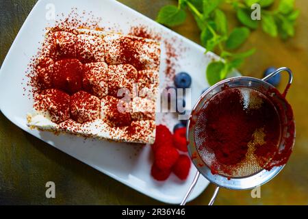 Tiramisu wird mit Kakaopulver abgewischt Stockfoto