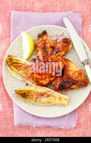 Gegrillte Hähnchenflügel mit gebackener Chicorée Stockfoto