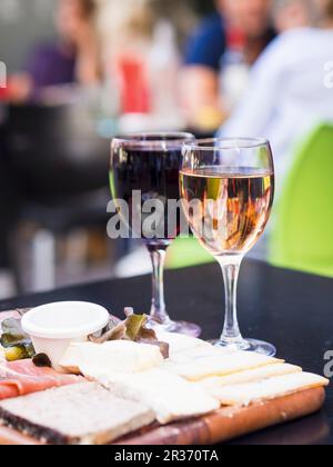 Rot-weiße Bordeaux-Weine werden zusammen mit Fleisch- und Käseplatte in einem der Restaurants in Bordeaux serviert Stockfoto