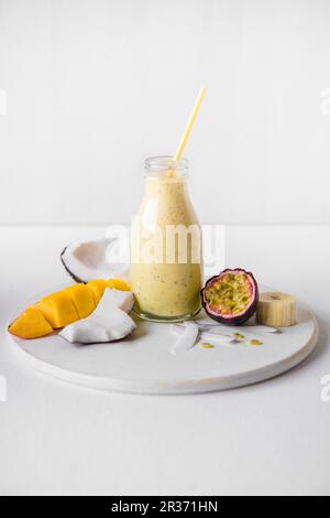 Ein Kokosmilch-, Mango-, Bananen- und Passionsfrucht-Smoothie Stockfoto