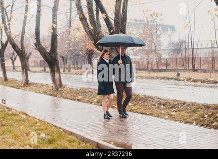 Junges Paar unter einem Regenschirm Stockfoto