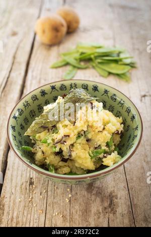 Vegane gedämpfte Kartoffeln mit knusprigem Algenspeck und Zuckersnacks Stockfoto