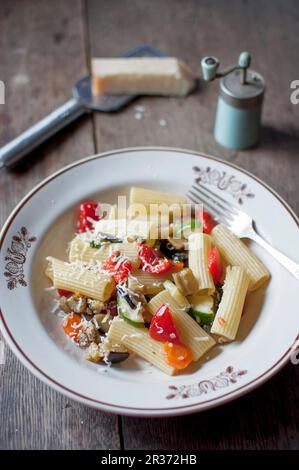 Rigatoni ortolana. Pasta mit Gemüse (Zucchini, Aubergine, roter Pfeffer, Karotten, Tomaten, Knoblauch und Zwiebeln). Serviert mit geriebenem Parmesankäse und Stockfoto