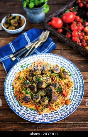 Vegan aubergine Frikadellen auf einem Bett von Spaghetti mit Tomatensauce und Oliven Stockfoto