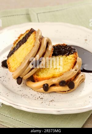 Scheiben Kaffee „Gugelhupf“-Ringkuchen mit Schokoladensoße Stockfoto