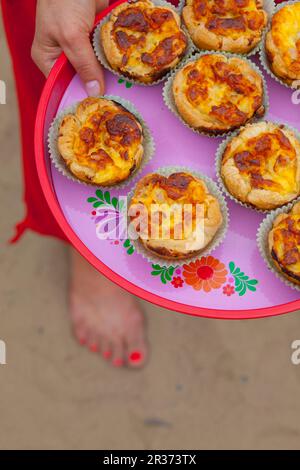 Blättern Sie Gebäck-Muffins mit Schinken und Käse für ein Picknick am Strand Stockfoto