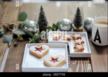 Zwei Gebäckstücke in kleinen Schüsseln und eine Weihnachtstischdekoration Stockfoto