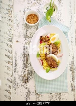 Gebratene Gänseleber mit Salat, Ei, Frühlingszwiebeln, Radieschen und einem Knoblauchdressing Stockfoto