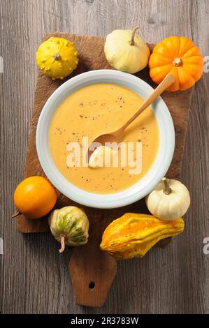 Kürbiscremesuppe und Zierrippen auf einem Holzbrett Stockfoto