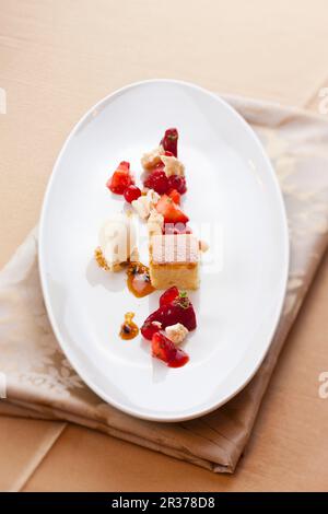 Ein Dessertteller mit Beeren, Vanilleeis und frischem Käsekuchen Stockfoto