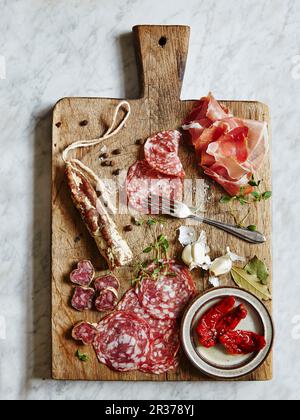 Feine Fleisch- und Wurstwaren. Auf einem vintage Schneidbrett serviert. Stockfoto