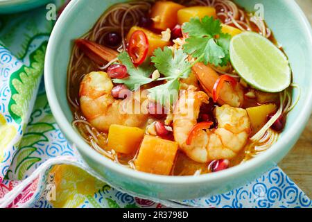 Schüssel mit Krabbensuppe Laksa mit Granatapfelgarnelen und Koriander Stockfoto