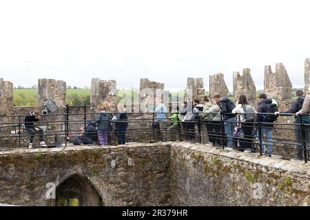 Leute, die anstehen, um den Blarney-Stein auf dem Gipfel des Blarney-Schlosses in Irland zu küssen. Stockfoto