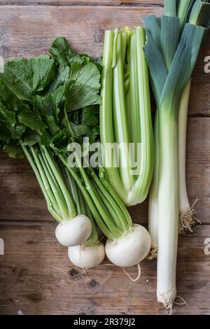 Weißen Rübe, Sellerie und Lauch auf einer hölzernen Hintergrund Stockfoto