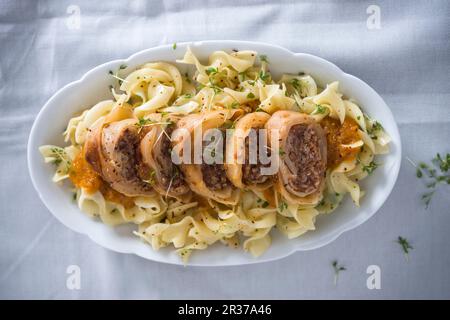 Kohlrollen gefüllt mit Rindfleisch auf Pasta mit roter Gemüsesauce (vegan) Stockfoto