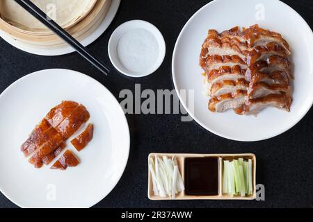 Scheiben knuspriger Peking-Ente und Entenhaut mit Pfannkuchen, Frühlingszwiebeln, Gurke und Hoisin-Sauce Stockfoto