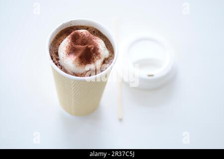 Eine Tasse Kakao mit Sahne in einer Tasse zum Mitnehmen Stockfoto