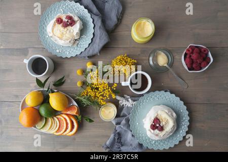 Baiser Nester mit Lemon Quark, Zitrusfrüchte und Himbeeren Stockfoto