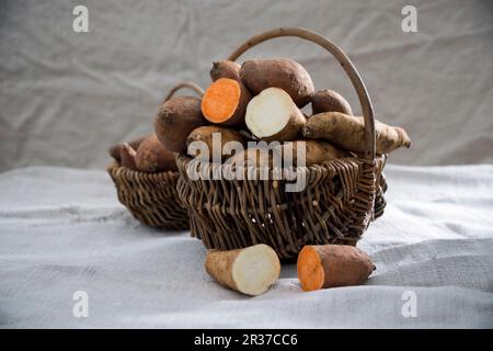 Weiße und rote Süßkartoffeln in einem Korb Stockfoto