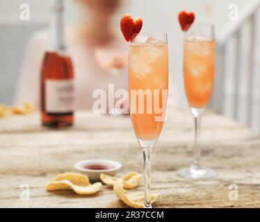 Champagner-Cocktails mit Hibiskus und Erdbeerherzen Stockfoto