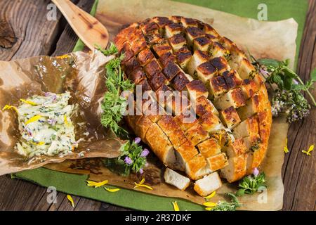 Ziehen neben Brot mit Kräuterbutter Stockfoto