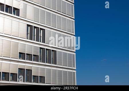 Bürogebäude mit geschlossenen Jalousien vor einem blauen Himmel Stockfoto
