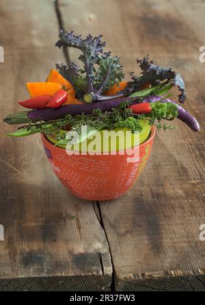 Ein Gemüse Schüssel mit Grünkohl, Chilis, Kürbis und lange, dünne Auberginen Stockfoto