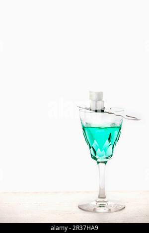 Absinth mit einem Absinthlöffel und Zuckerwürfel in einem Kristallglas Stockfoto