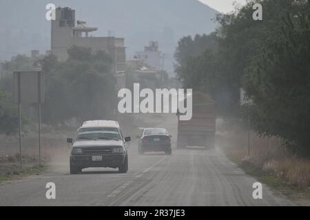 Puebla. 22. Mai 2023. Dieses Foto wurde am 22. Mai 2023 aufgenommen und zeigt Fahrzeuge, die durch die Asche fahren, die durch die Aktivität des Vulkans Popocatepetl im Bundesstaat Puebla, Mexiko, verursacht wurde. Am Sonntag erhöhten die mexikanischen Behörden die Alarmstufe aufgrund der jüngsten erhöhten Aktivität des Vulkans Popocatepetl. Die Alarmstufe wurde von der gelben Phase zwei auf die gelbe Phase drei erhöht, einen Schritt unter der roten Alarmstufe, sagte Laura Velazquez, Leiterin der mexikanischen Nationalen Katastrophenschutzbehörde, bei einer Pressekonferenz. Kredit: Xin Yuewei/Xinhua/Alamy Live News Stockfoto